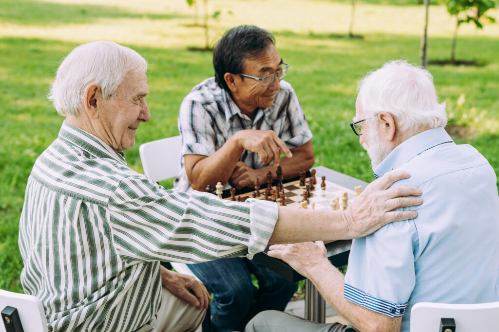 Group of senior friends playing chess at the park